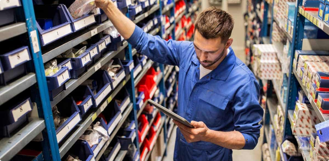 A close up shot of a person stocking a warehouse shelf